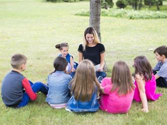 A teacher reading to a class outside