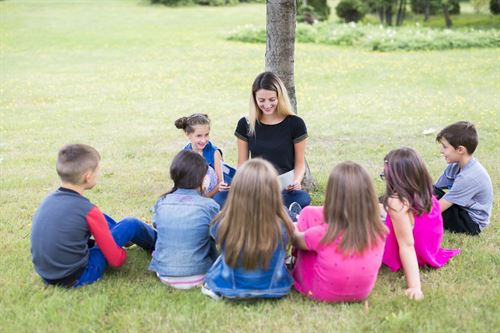A teacher reading to a class outside